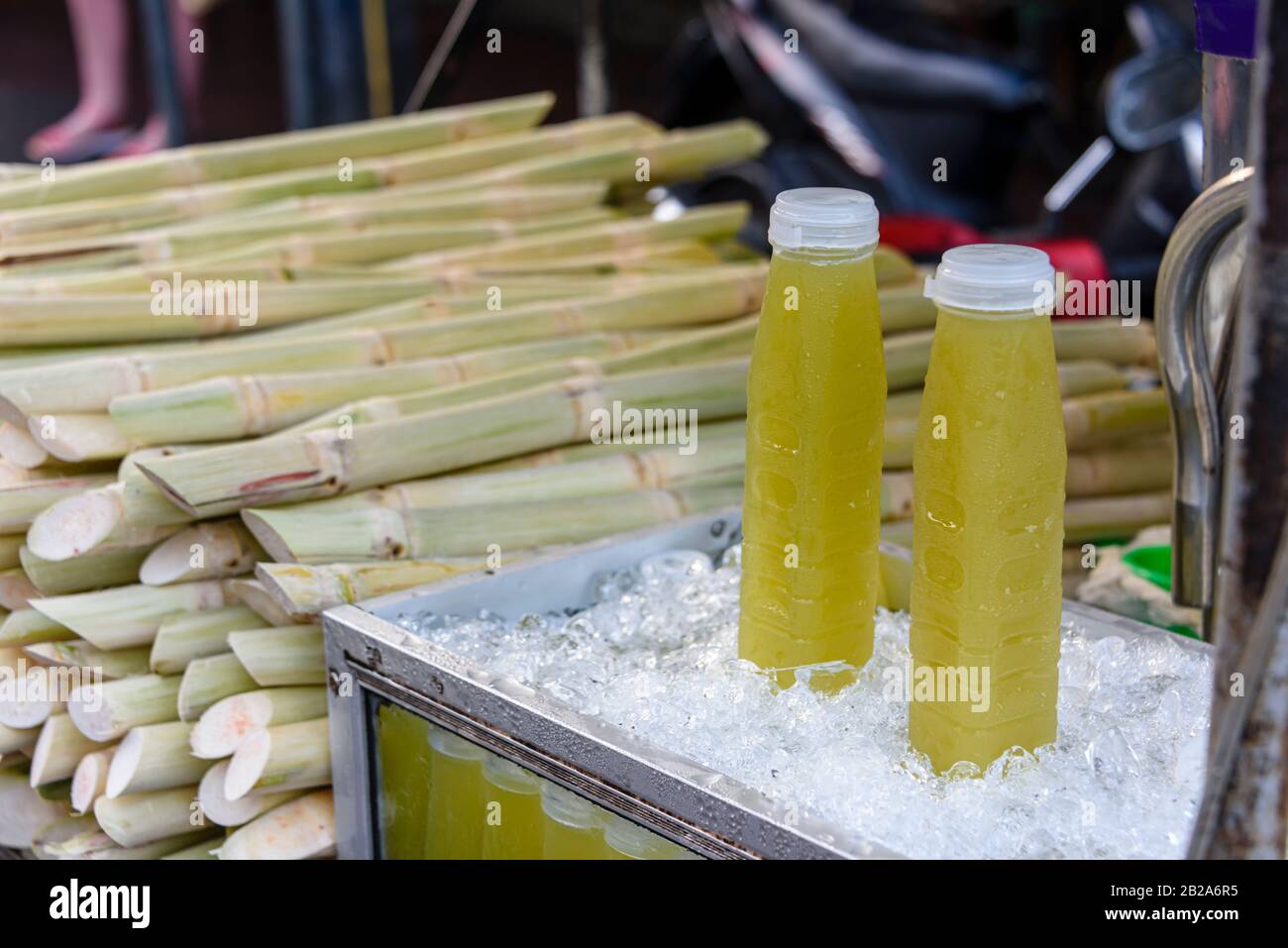 Plastic bottles on ice containing pulped sugar cane for sale on a street stall, Bangkok, Thailand Stock Photo