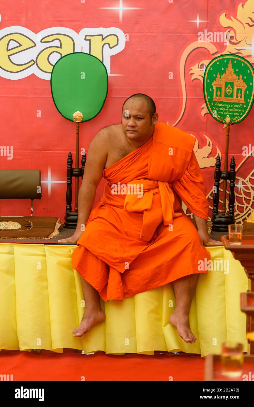 A Buddhist monk sits on a table in Bangkok, Thailand Stock Photo