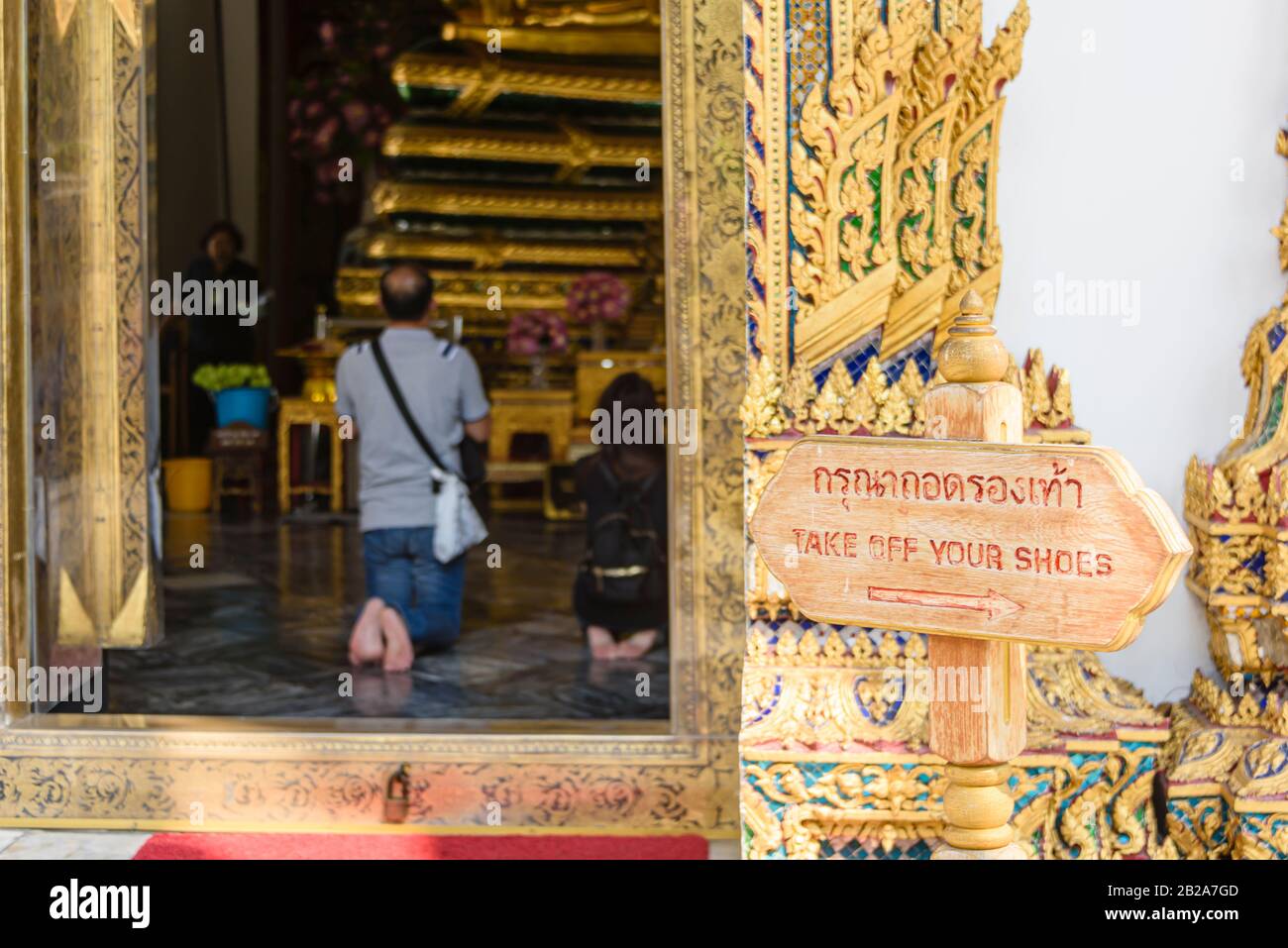 Sign at a Buddhist temple asking people to take off their shoes, Wat Pho, Bangkok, Thailand Stock Photo