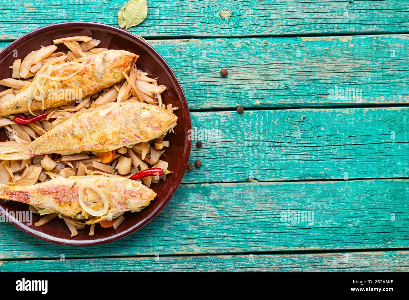 Spicy mullet fish fried with horseradish roots and jerusalem artichoke