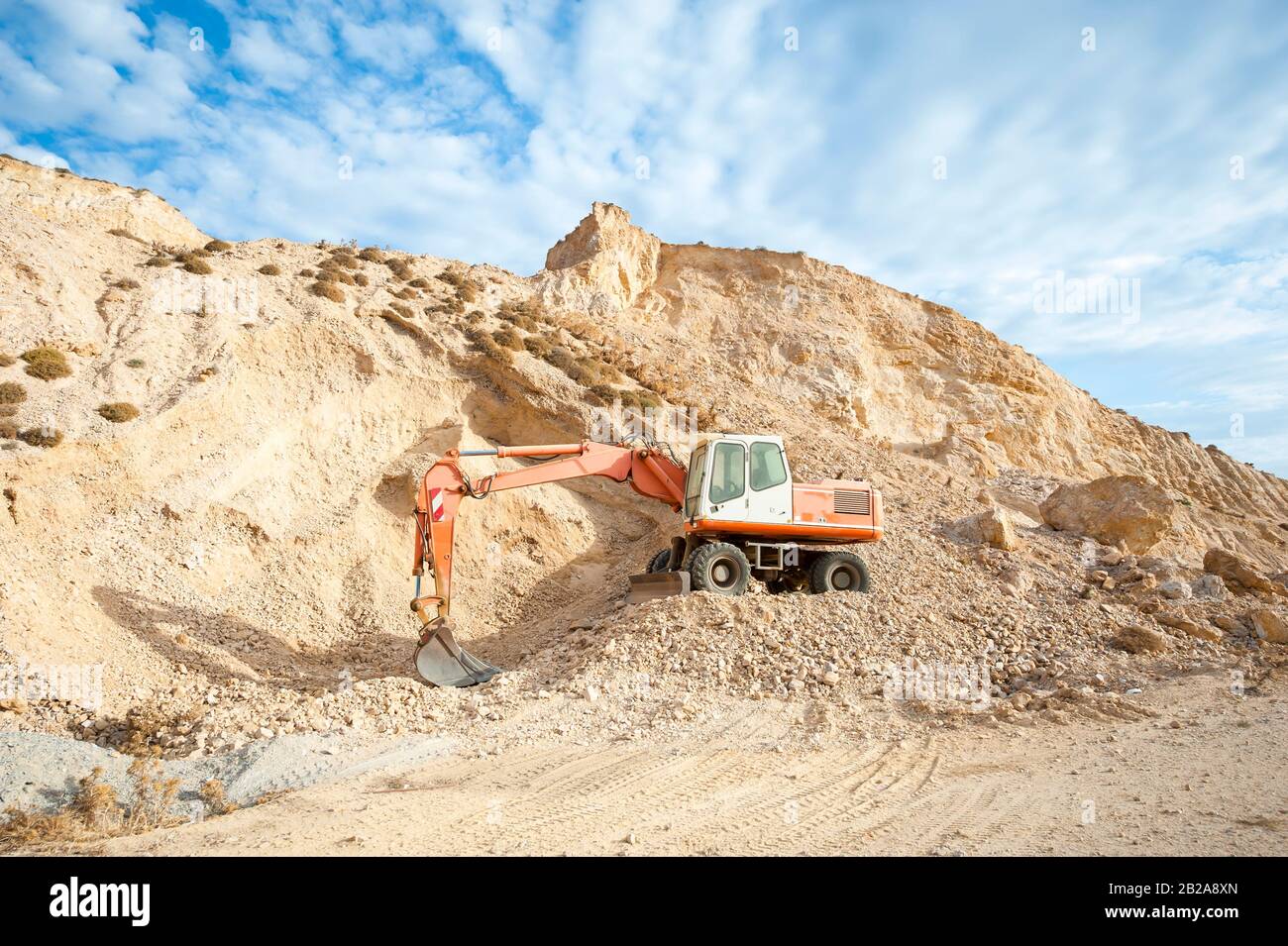 Digger Digging Rocks Empty inactive digger equipment sitting on dry mountainside with rocks ...