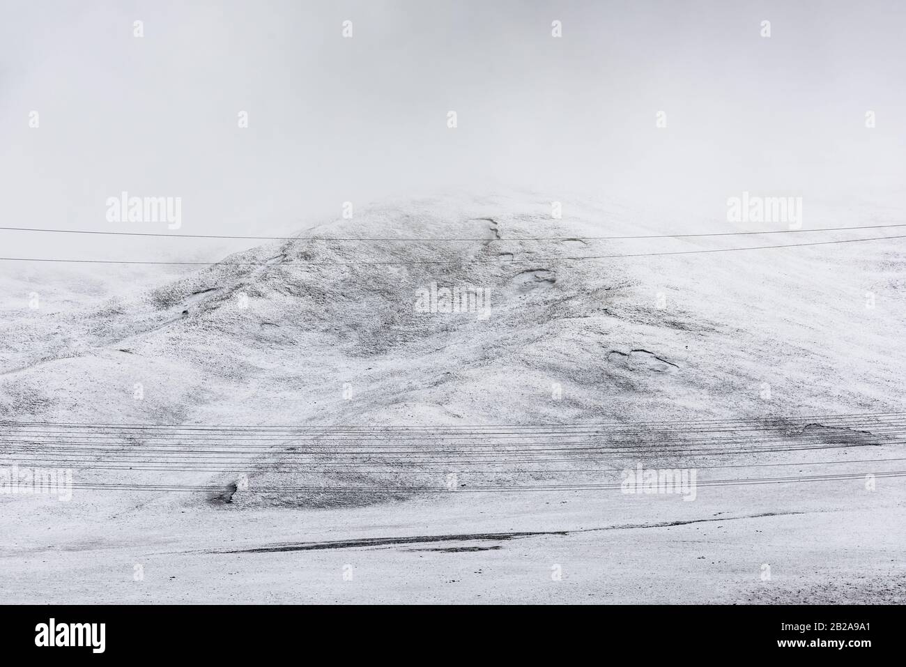 telegraph pole,  electric wire and mountain which covered with snow Stock Photo