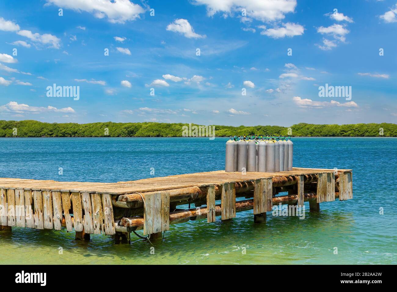 Group of air tanks standing on wooden jetty in the sea Stock Photo
