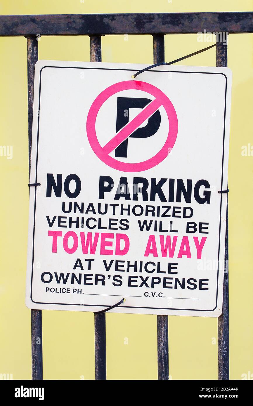 No unauthorized parking traffic sign on metal bars of fence Stock Photo