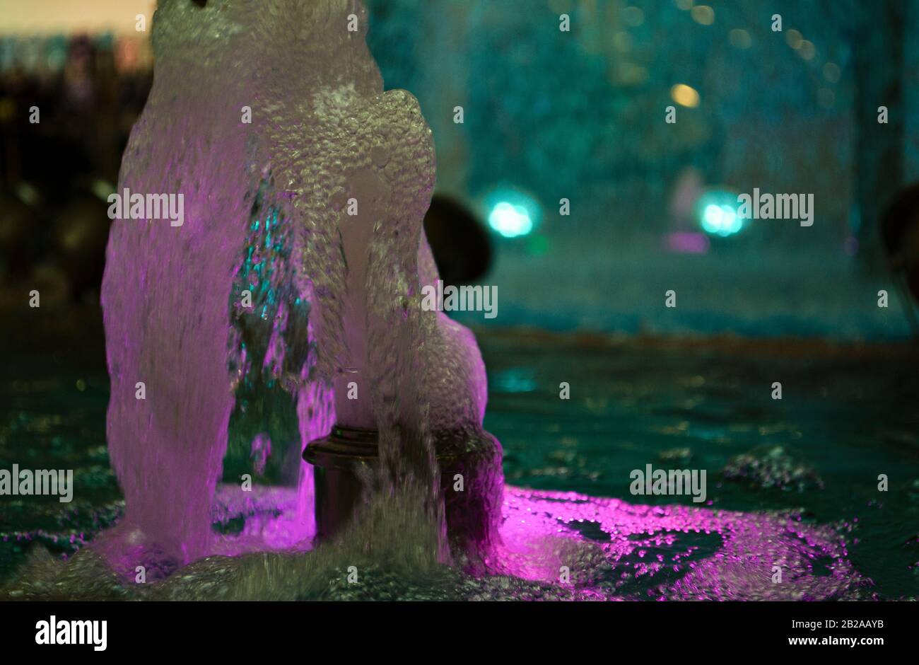 Blurred water background. Backlit water jet in the fountain. Stock Photo