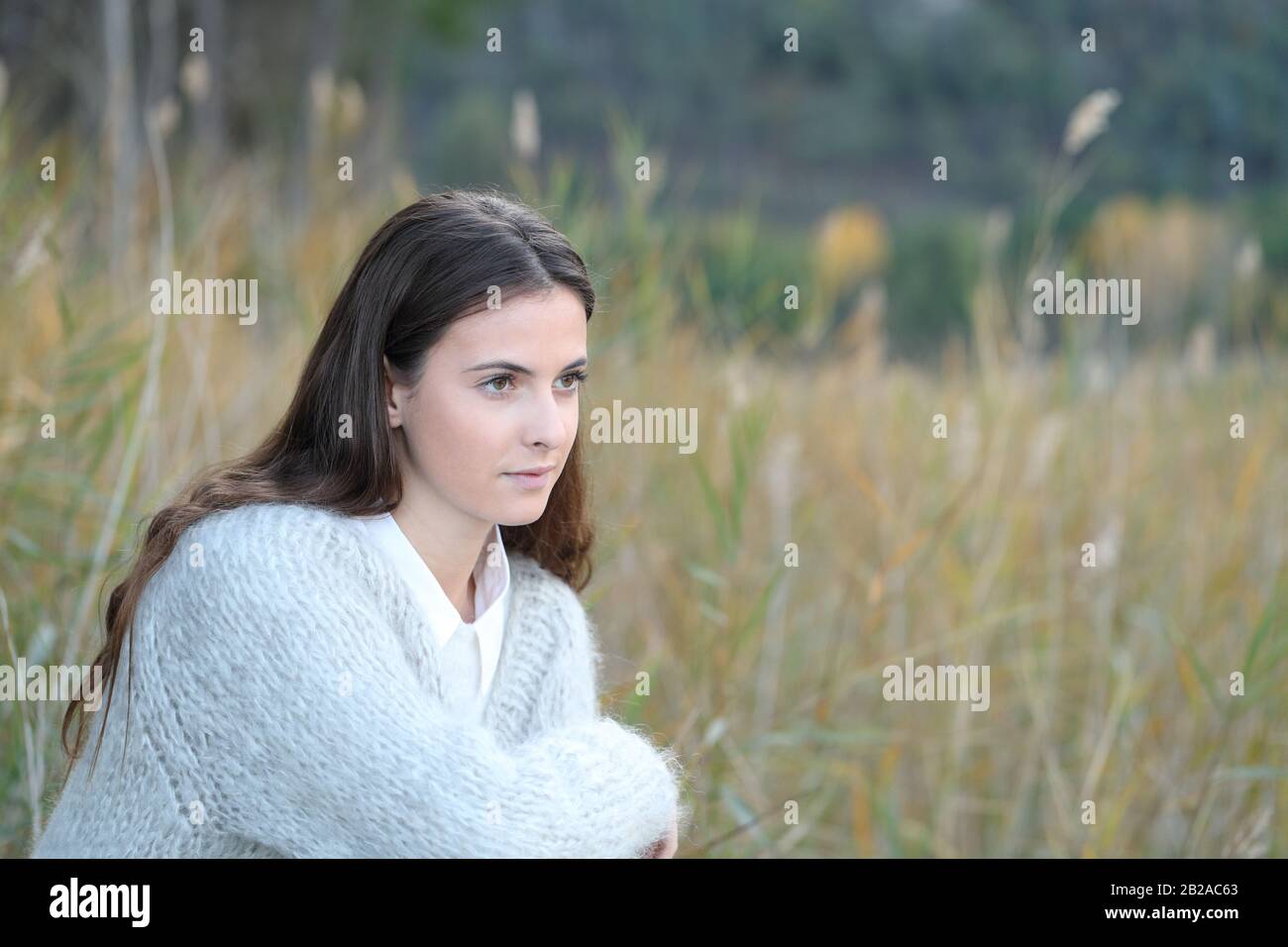 Portrait of a pensive serious teenage girl thinking looking away on a field Stock Photo