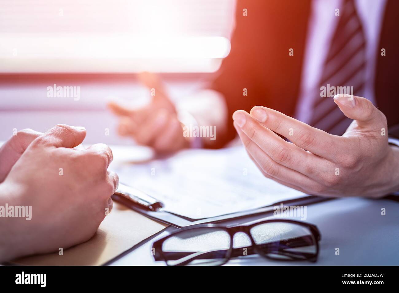 Business people negotiating a contract. Human hands working with documents at desk and signing contract. Stock Photo
