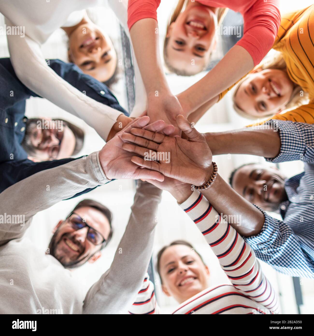 Close up view of young business people putting their hands together. Stack of hands. Unity and teamwork concept. Stock Photo