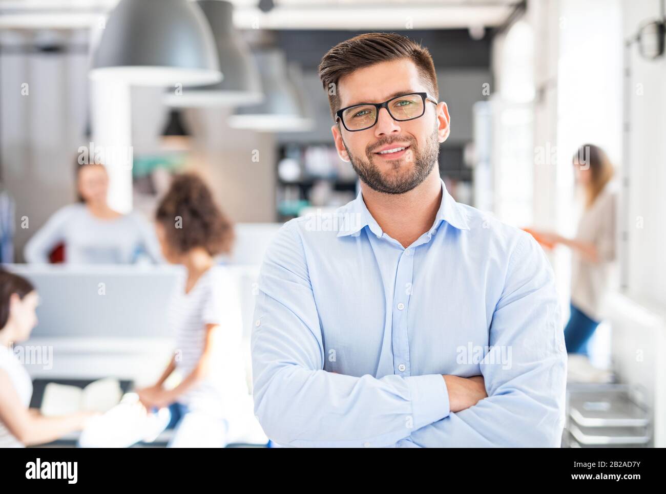 Portrait of young confident man leader standing in office. New start up business concept. Stock Photo