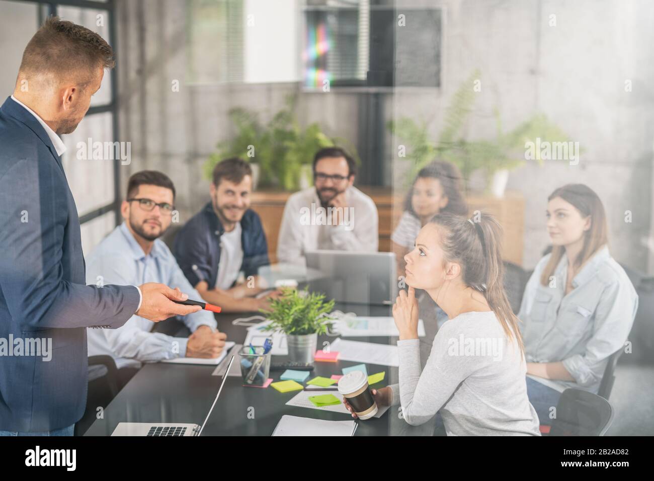 Business coach. Team leader teaches employees at a business meeting in a conference room. Stock Photo