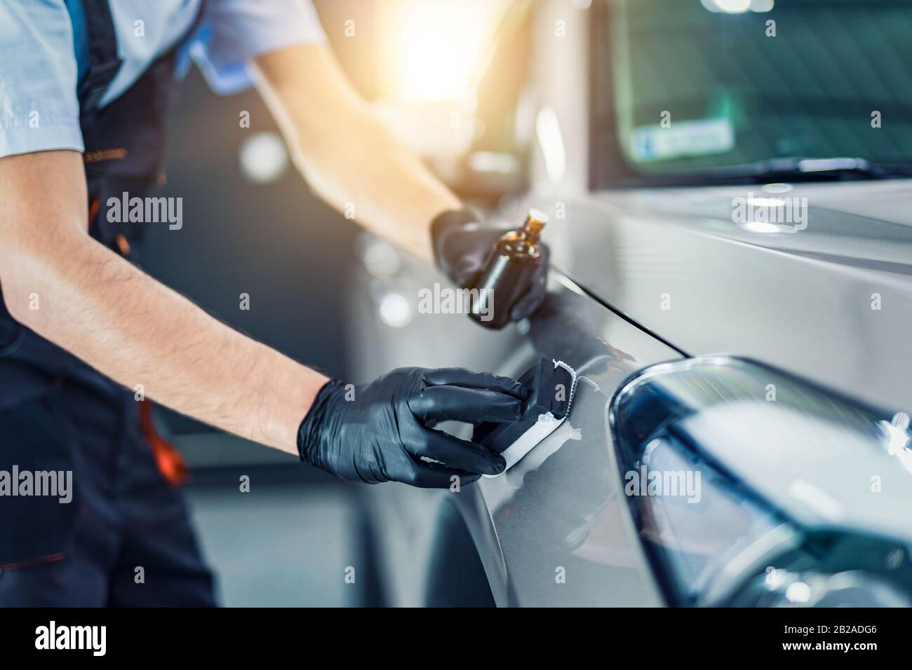 Car detailing - Man applies nano protective coating to the car. Selective focus. Stock Photo