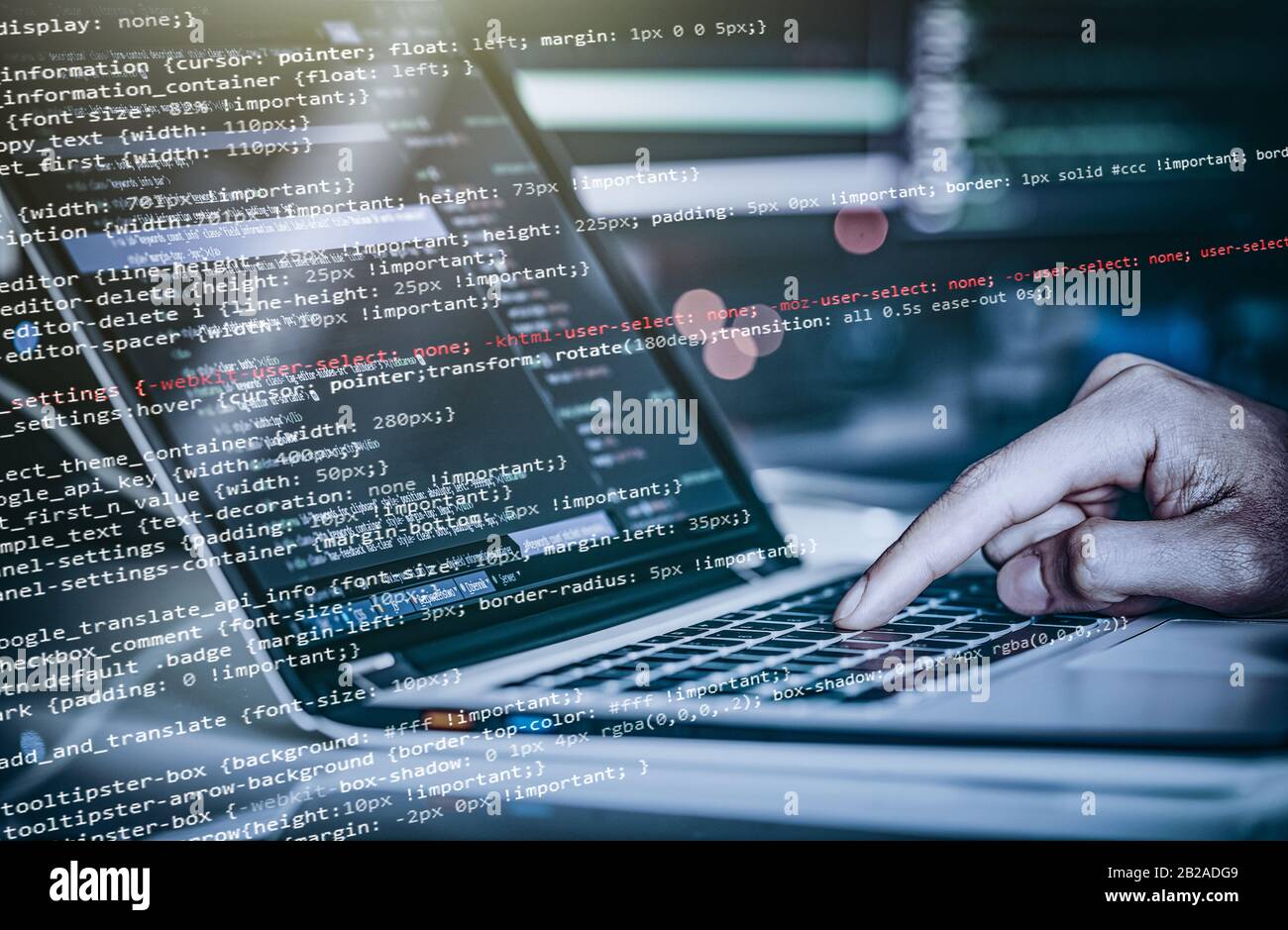 Hacker using laptop. Lots of digits on the computer screen. Stock Photo