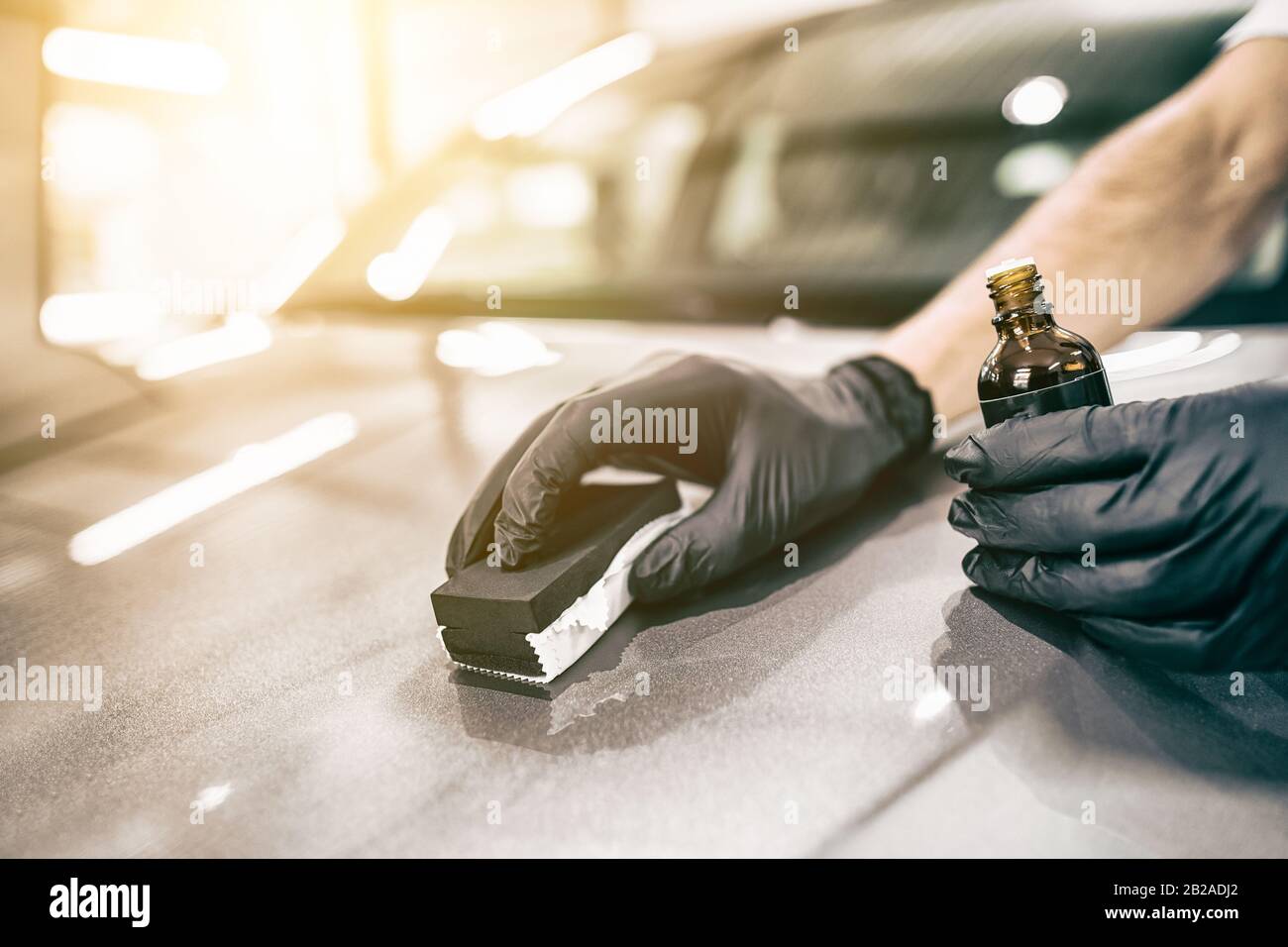 Car detailing - Man applies nano protective coating to the car. Selective focus. Stock Photo
