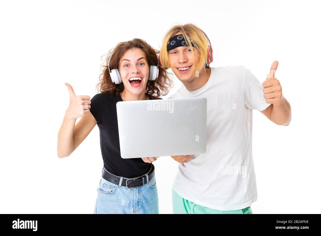 Stylish caucasian blonde man and young woman shows laptop and listen to music isolated on white background Stock Photo