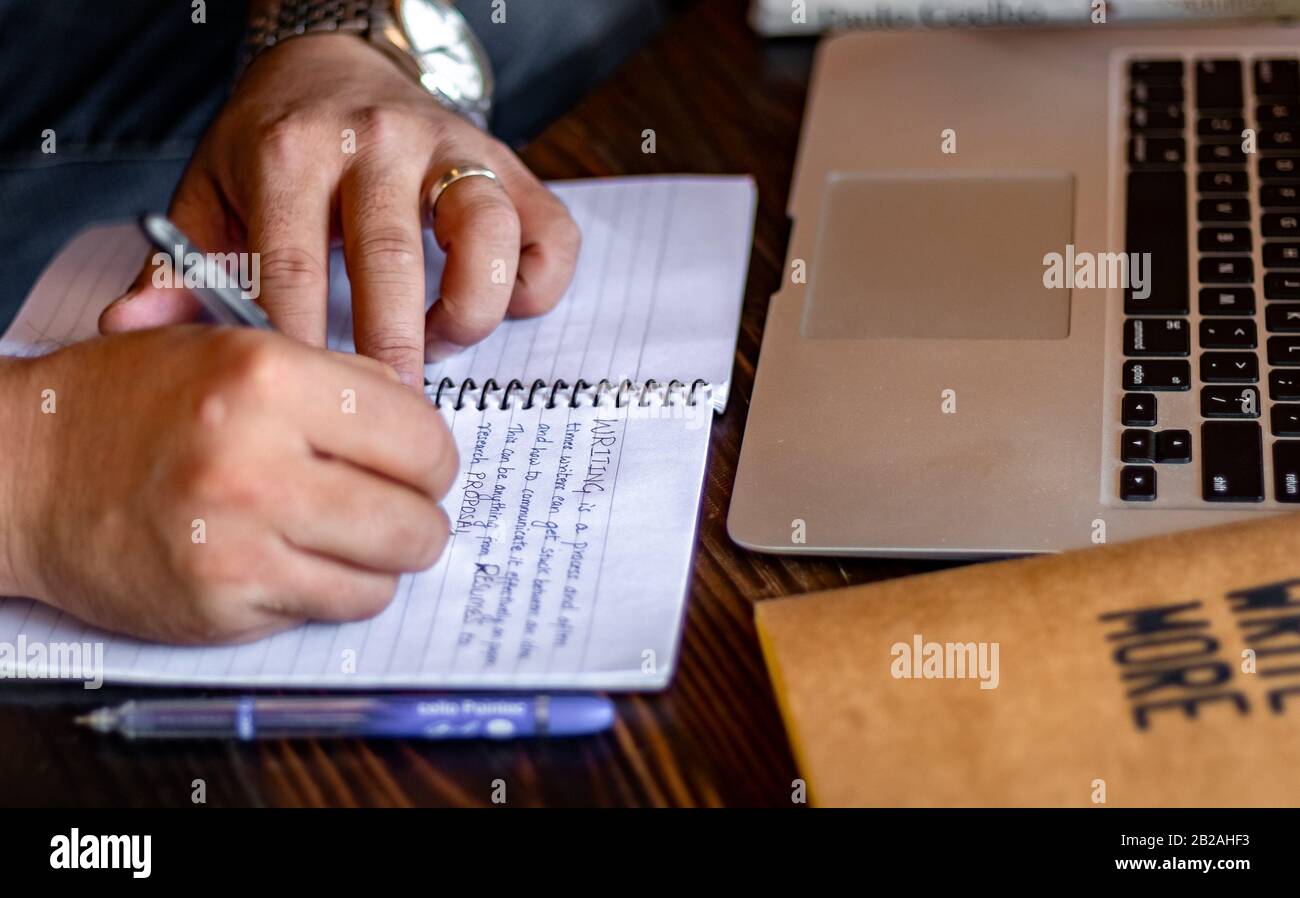 Hand of a young businessman taking notes with a fountain pen on a