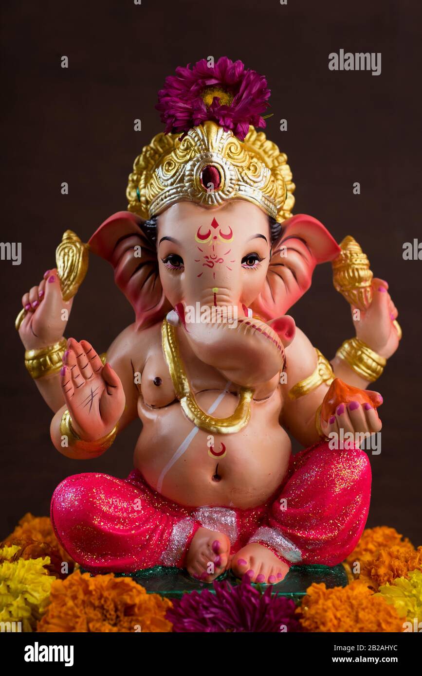 Hindu God Ganesha. Ganesha Idol on dark wooden background Stock Photo -  Alamy