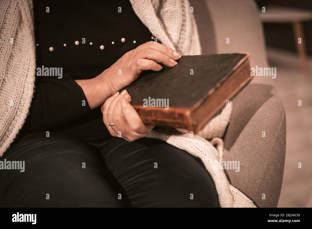 Senior Woman Holds Old Book In Her Hands Close Up. Stock Photo