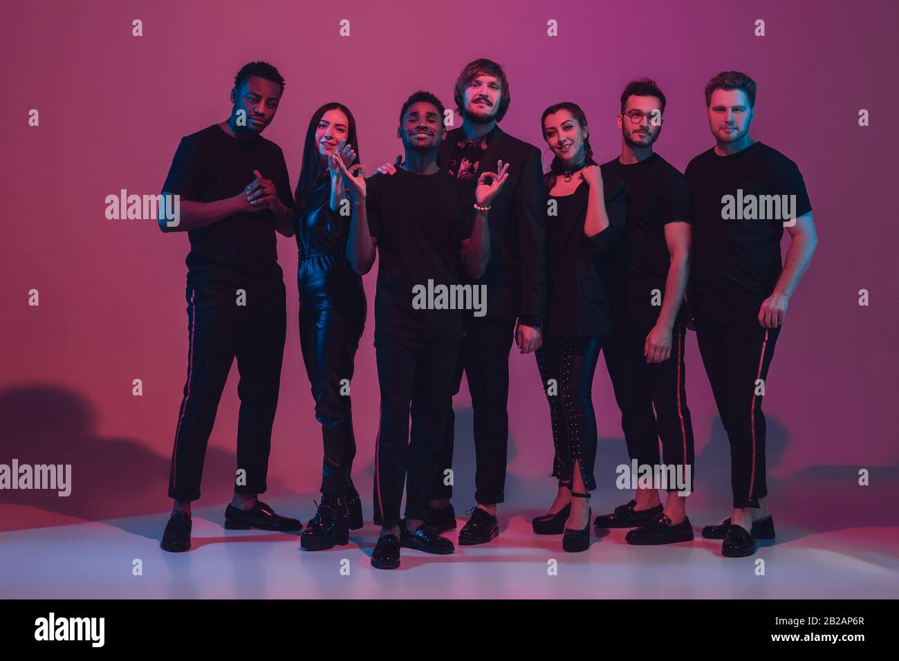 Group of young multiethnic musicians created band, dancing in neon ...