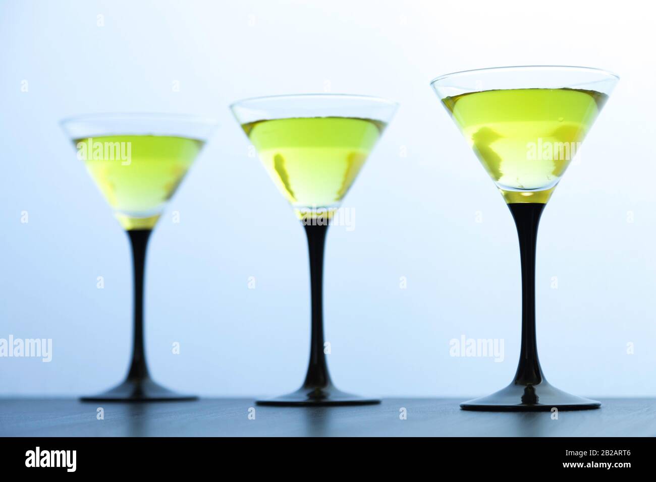 three yellow cocktails glasses in line on white background Stock Photo