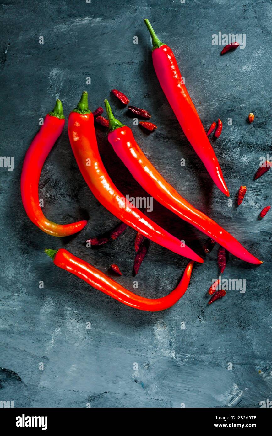 fresh red spicy peppers and cayenne peppers on dark background from above. Top view. Stock Photo