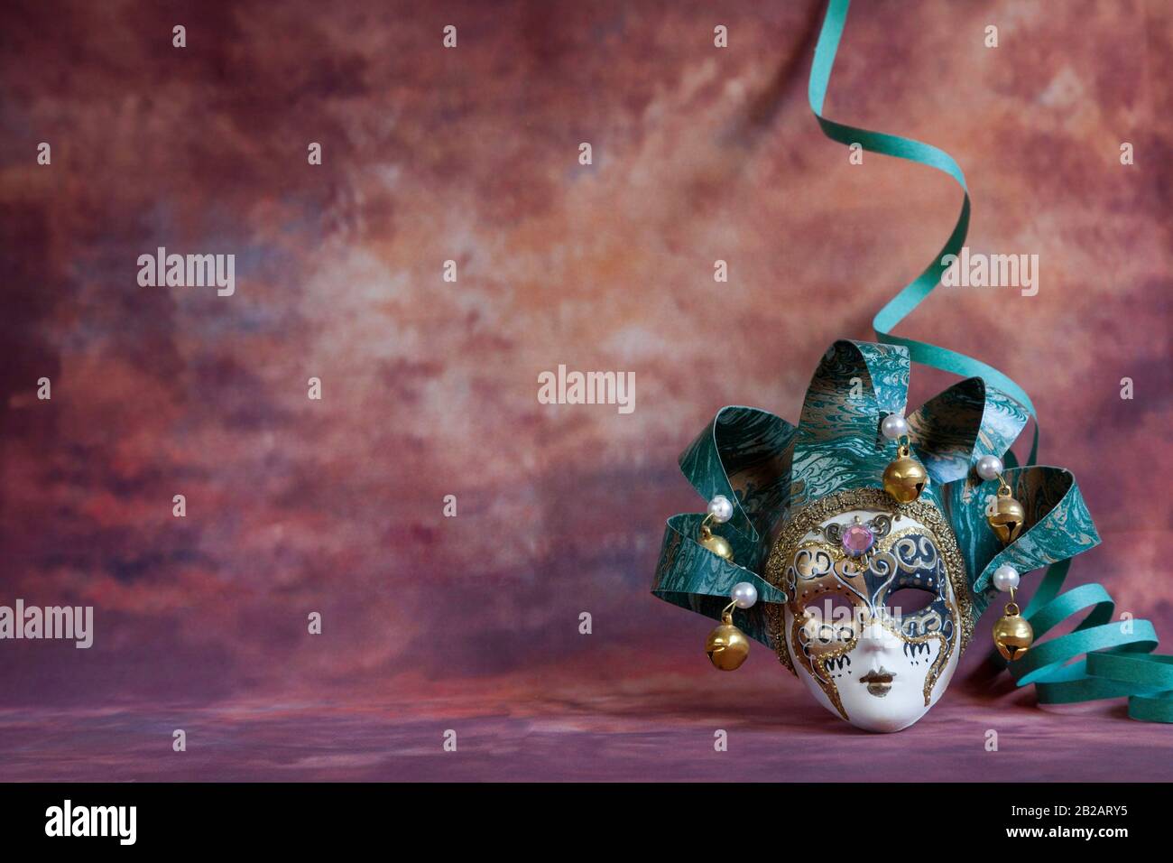 venetian carnival mask and serpentine on brown fantasy background. Stock Photo