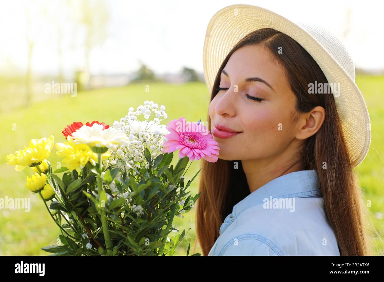 Brazilian pretty beautiful girl smells flowers outdoor Stock Photo