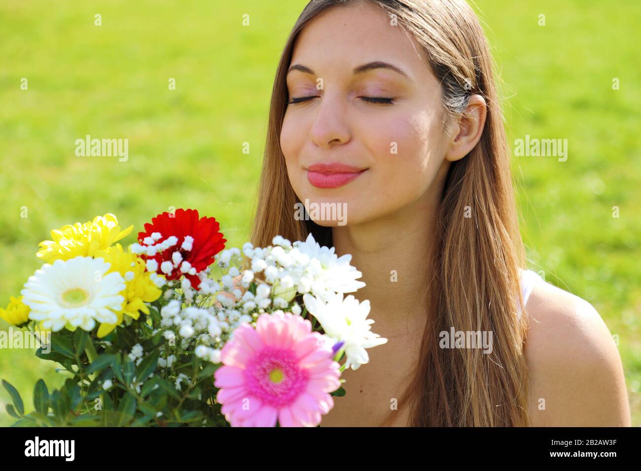Portrait of a young woman smelling bouquet of flowers outdoor Stock ...