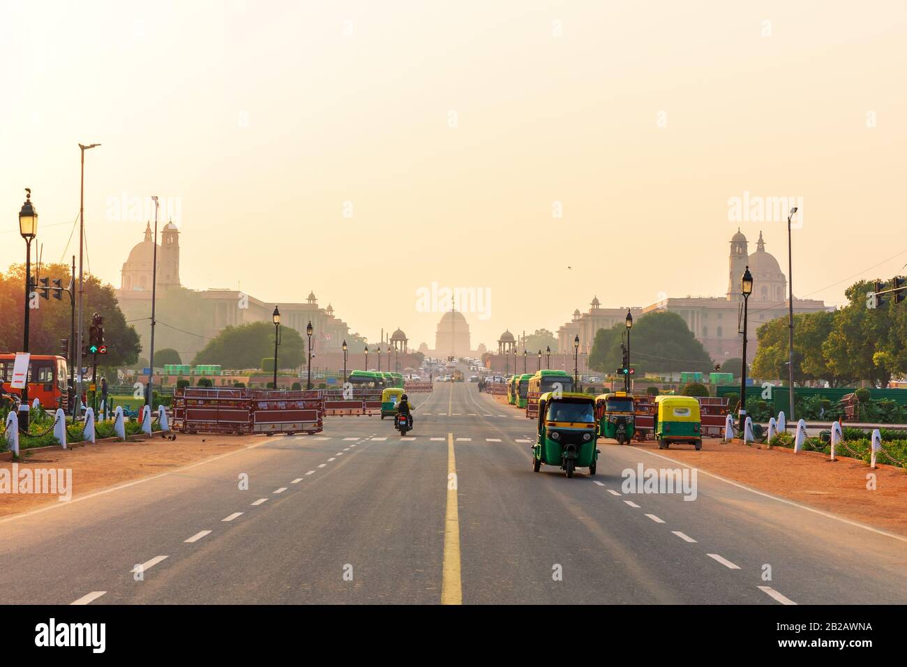 Sunset traffic in New Delhi, tuc tuc cars on the road to the Presidential Residance. Stock Photo