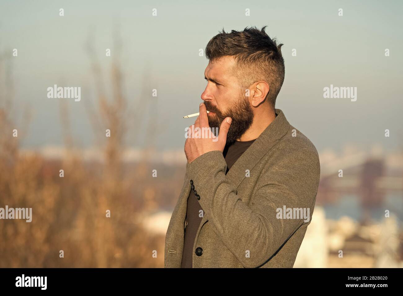 hide cigarette smoke Cigarette tobacco harmful health influence. Smoking aesthetics. Smoking  devices concept. Bearded hipster smoking outdoors. Device hide conceal smell  of smoke. Handsome man smoke flying out of mouth Stock Photo