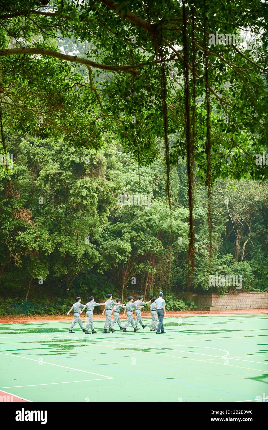 A group of teenagers during a paramilitary training session at Wah Yan College. Wylie Road. Kowloon. Hong Kong. Stock Photo