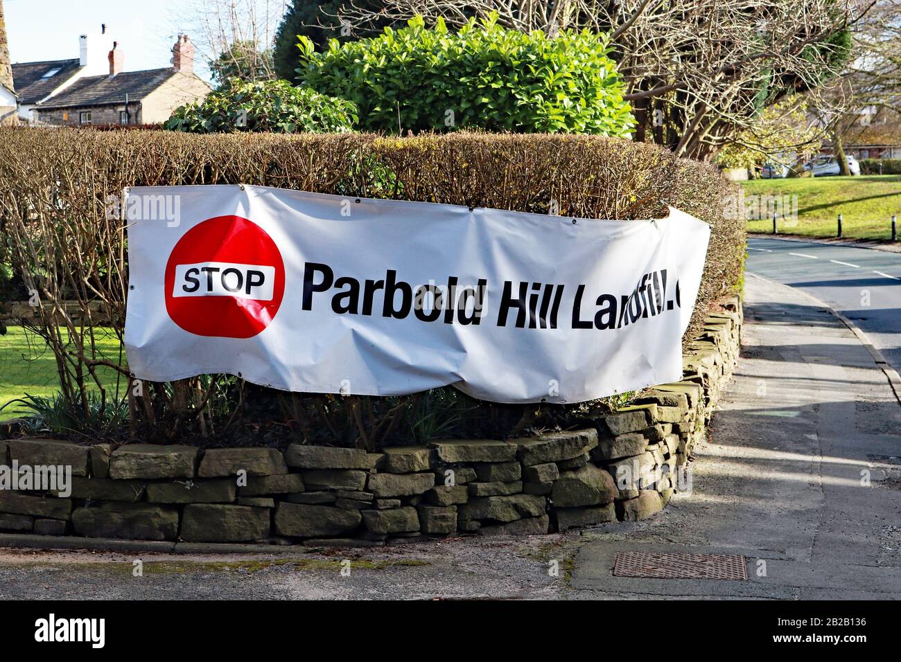 A long flexible landfill protest sign, on a hedge alongside the A5209 in Newburgh. There is local concern about tipping at a former land fill site. Stock Photo
