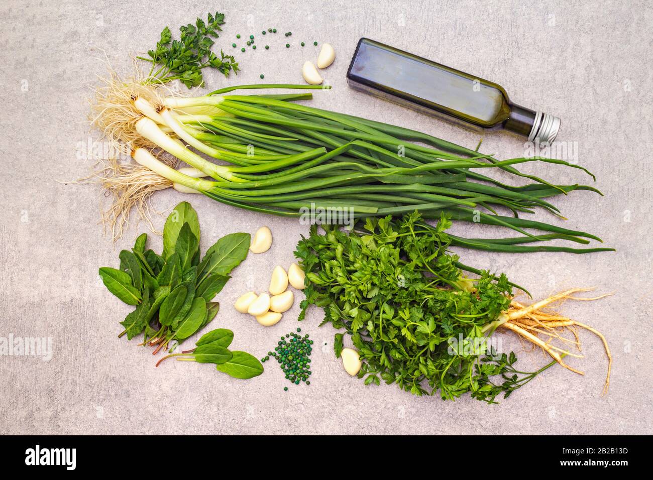 A bunch of fresh green onions, sorrel, parsley, garlic, olive oil and