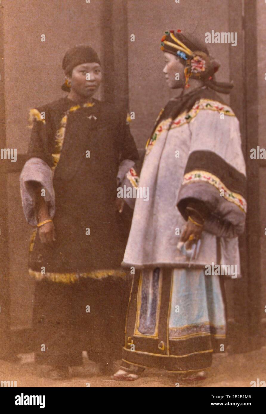 Early tinted photograph of a Chinese Han Lady and her servant, both woman have bound fett, 1879 China. Stock Photo