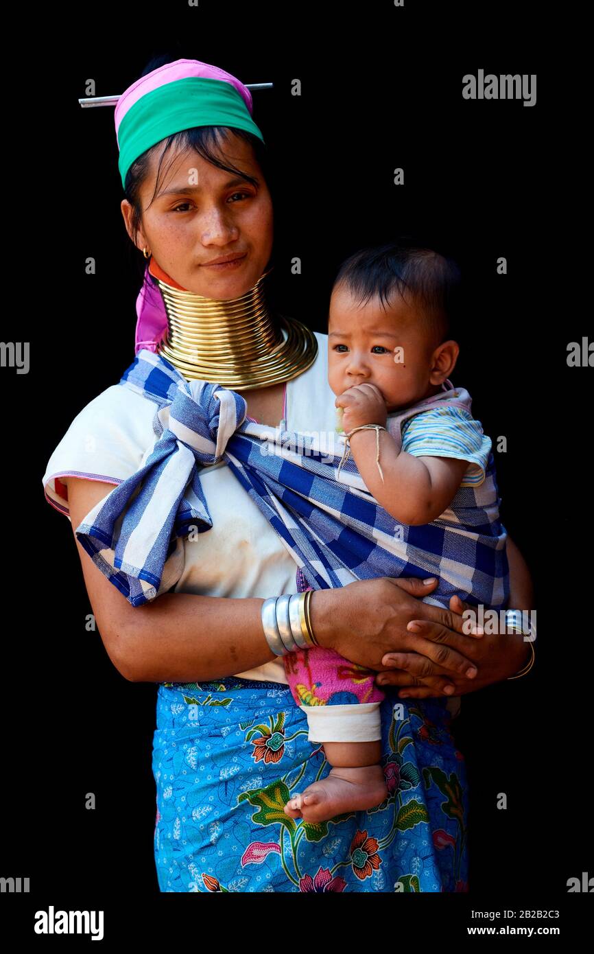 Kayan Lahwi woman carrying her baby and wearing brass neck coils and traditional clothing. The Long Neck Kayan (also called Padaung in Burmese) are a Stock Photo