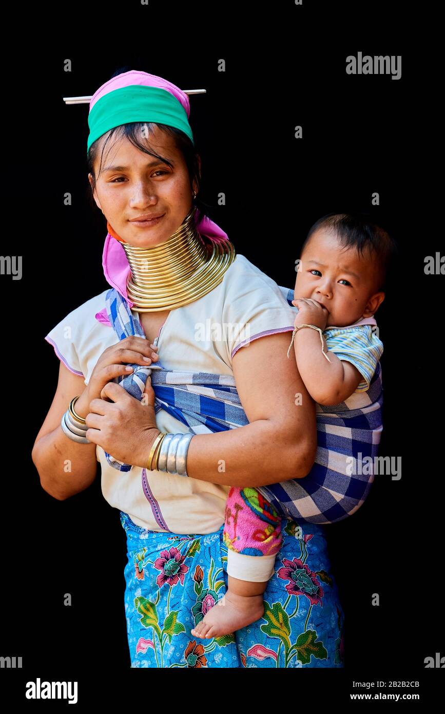 Kayan Lahwi woman carrying her baby and wearing brass neck coils and traditional clothing. The Long Neck Kayan (also called Padaung in Burmese) are a Stock Photo