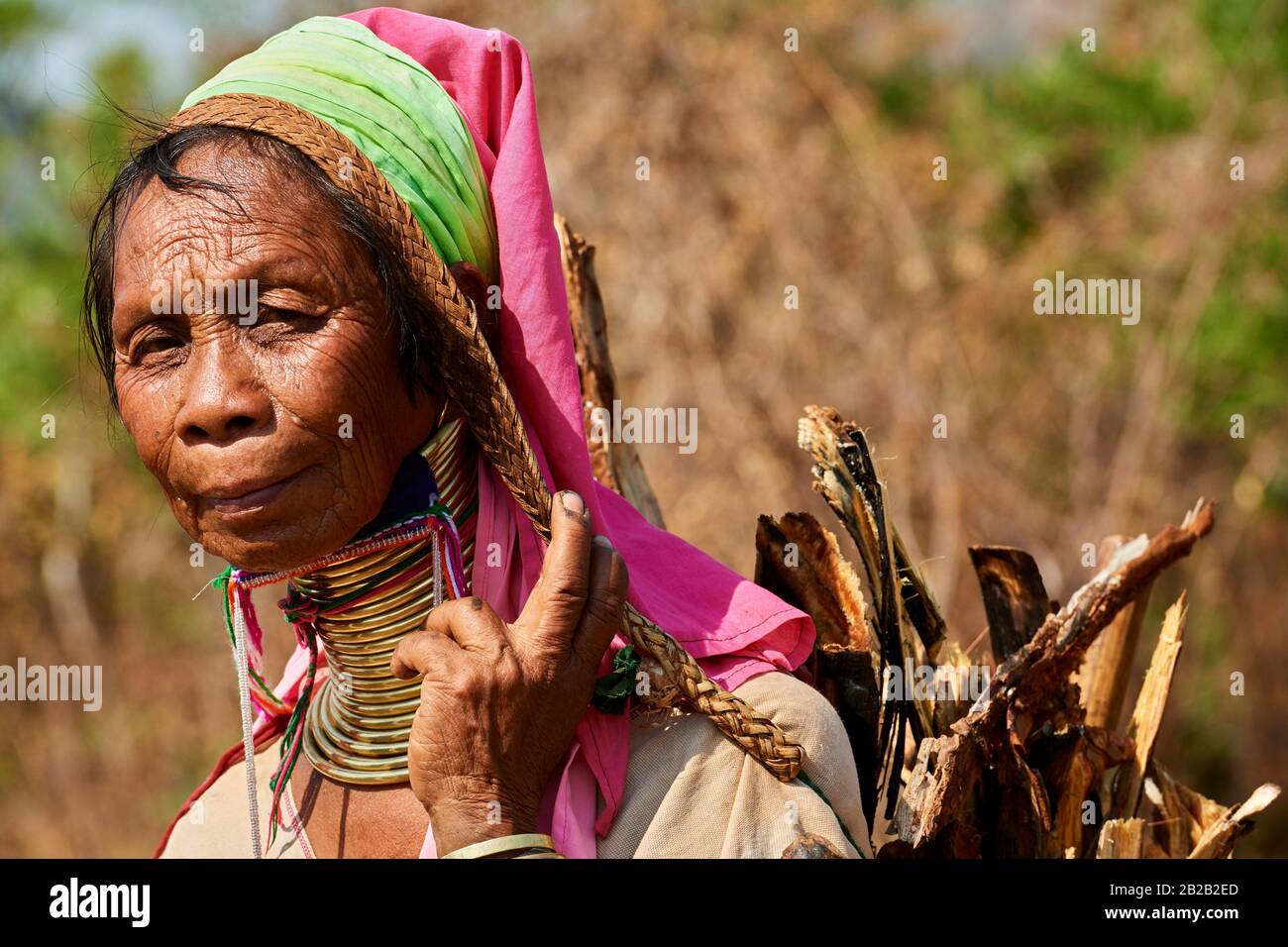Kayan Lahwi woman with brass neck coils and traditional clothing carrying charcoal she has collected in the forest. The ''Long Neck'' Kayan (also Stock Photo