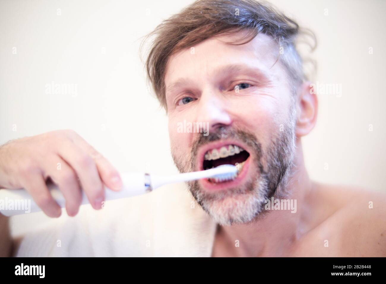 Man brushing his teeth with an electric toothbrush Stock Photo Alamy