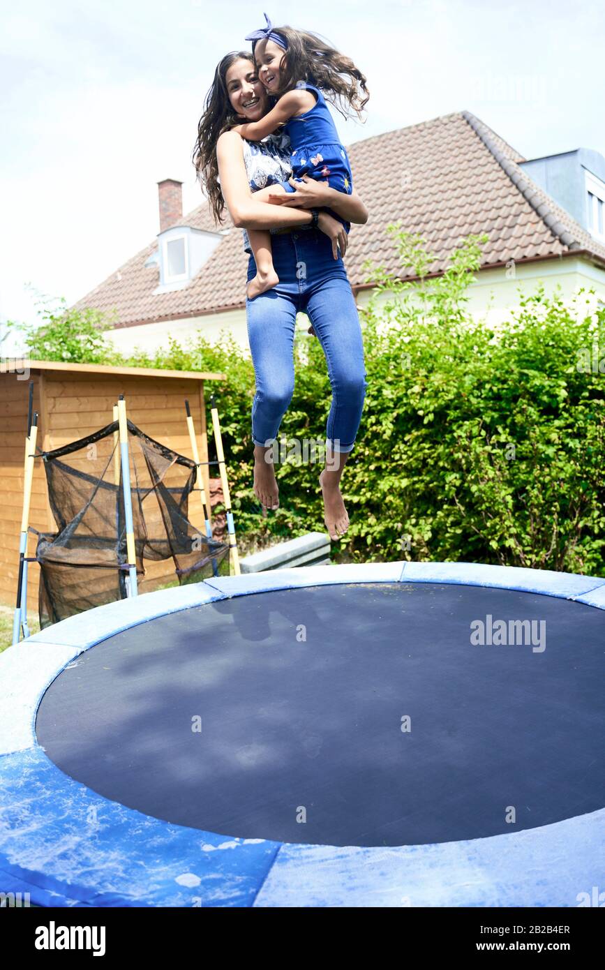 Young girl jumping on trampoline hires stock photography and images