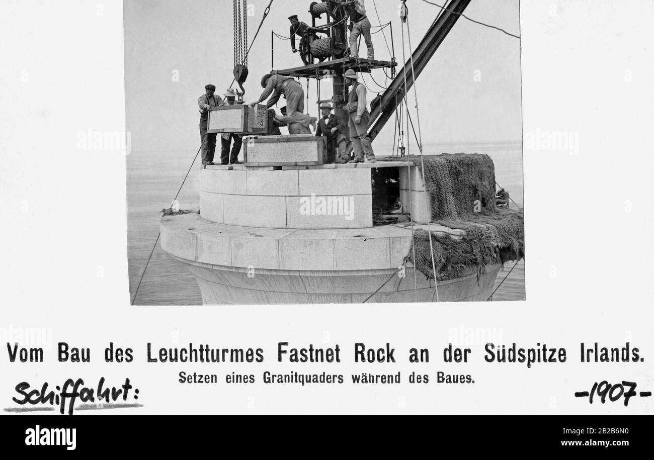 Construction of the Fastnet Rock lighthouse on the southern tip of Ireland. The construction workers are placing a granite block. Stock Photo