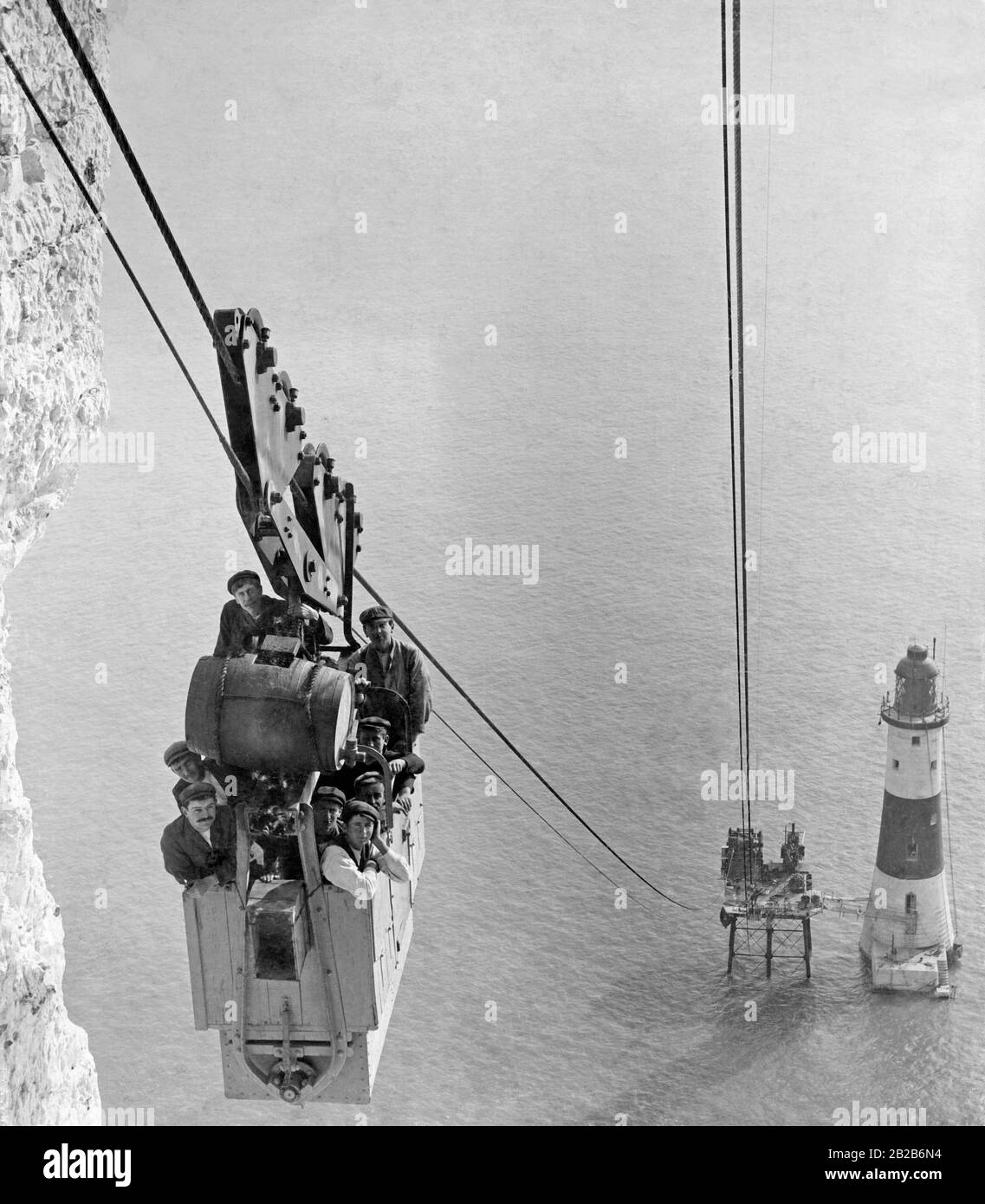 Construction workers take the cable car up to the chalk cliffs on the shore, during the construction of the lighthouse Beachy-Head. Stock Photo