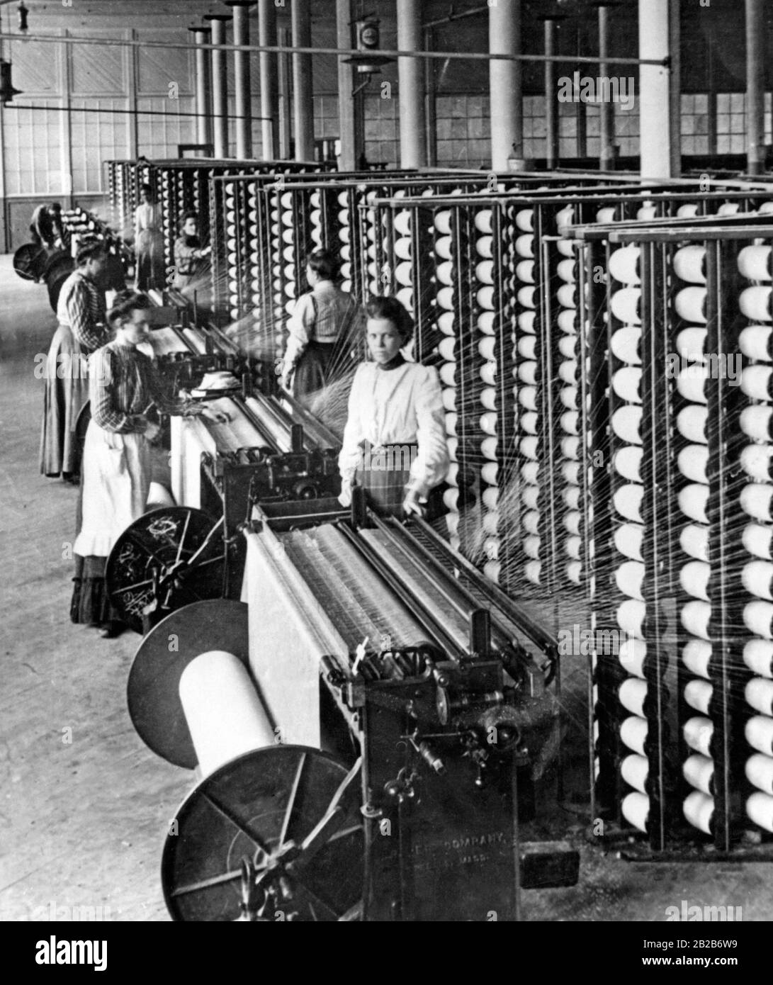 Women work with machines in a cotton spinning mill. Stock Photo