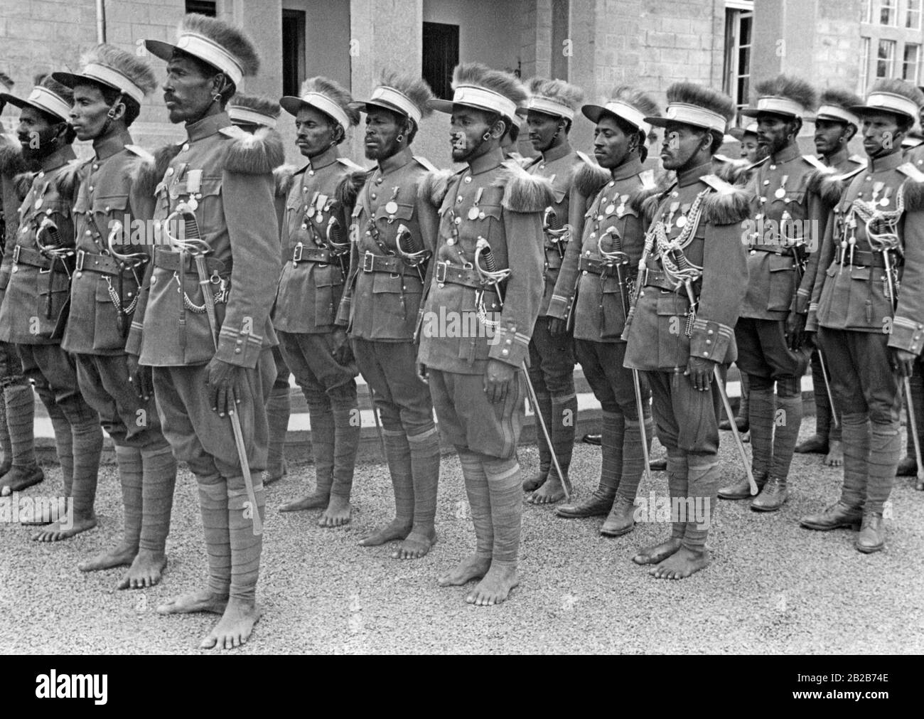 Abyssinian troops deployed in the war against Italy. They wear European-style uniforms but remain barefoot. Stock Photo