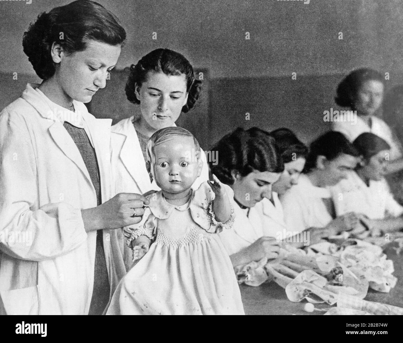 Turkish, unveiled young women during their training at the Ismet Pasha Institute in Ankara, where they learn domestic science and how to handle babies using dolls. Stock Photo