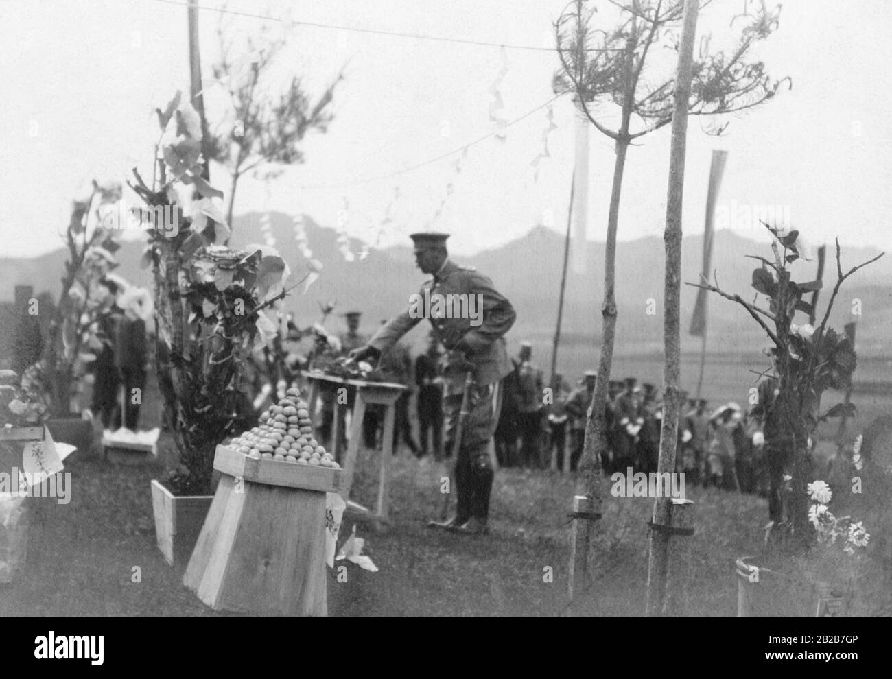 A German attache laying down a green branch to honor the japanese soldiers who died in the battle at the Yalu-river. Stock Photo