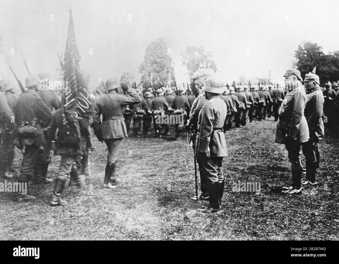 A German regiment marches by its Emperor William II during his visit near Smarhon. They carry captured Russian revolution flags. Stock Photo
