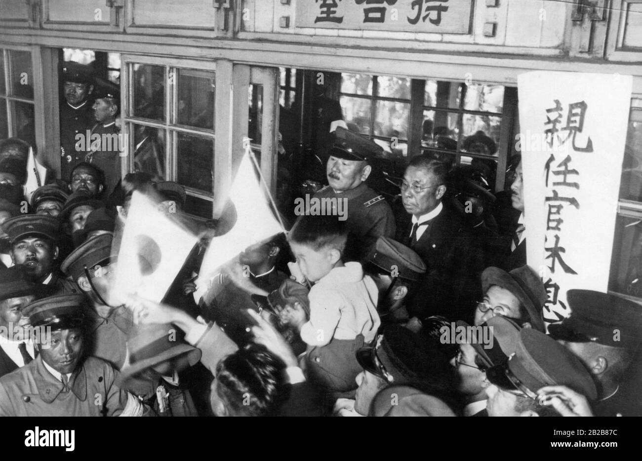 The Japanese Minister of War, General Minami Jiro (in the doorway on the left) and the Japanese Minister of Communications, Koizumi Matajiro (right) at the march of Japanese troops who are to be deployed in Manchuria to occupy the area. Stock Photo