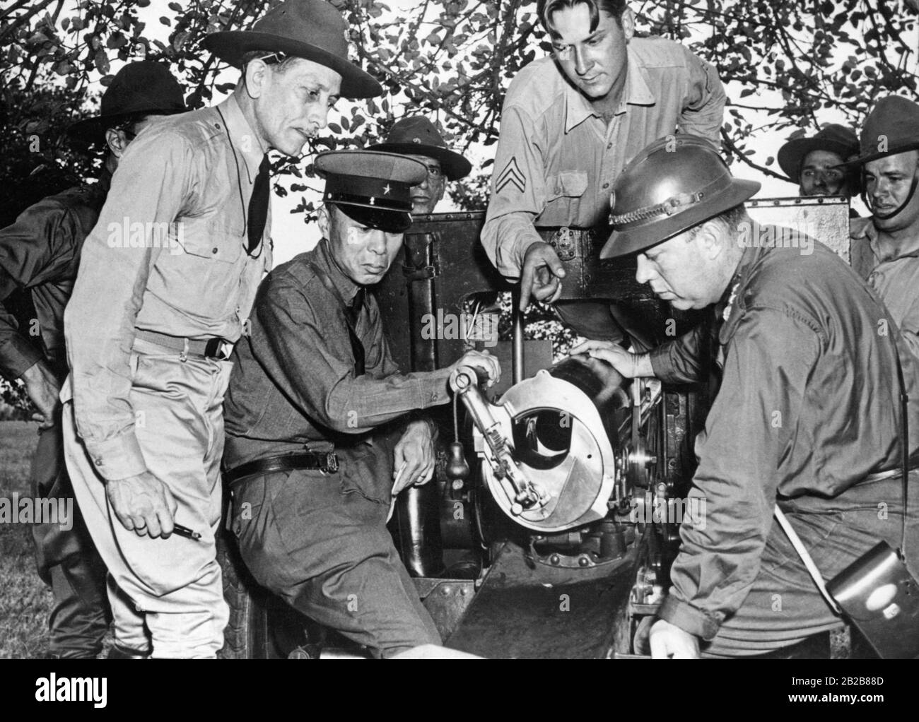 International military representatives inspect a gun of the US military during a visit to Manassas in the US state of Virginia on August 14, 1939. Left to right: Colonel Carlos Sanchez from Venezuela, General Major Masafumi Yamauti from Japan, the American representative Corporal Joe Soboleski and Major Jose Bina Machado from Brazil. Stock Photo