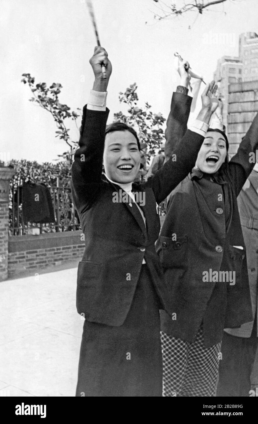 Two young Japanese women from Shanghai rejoice after hearing the news of the occupation of the Chinese Nanking by Japanese troops. The occupation took place during the Second Japanese-Chinese War. Stock Photo