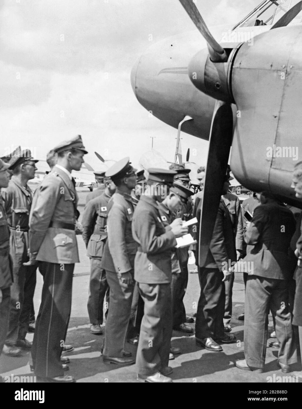 The leaders of a Japanese youth organization are visiting Tempelhoferfeld in Berlin. The group looks at a Junker Ju 86. Stock Photo