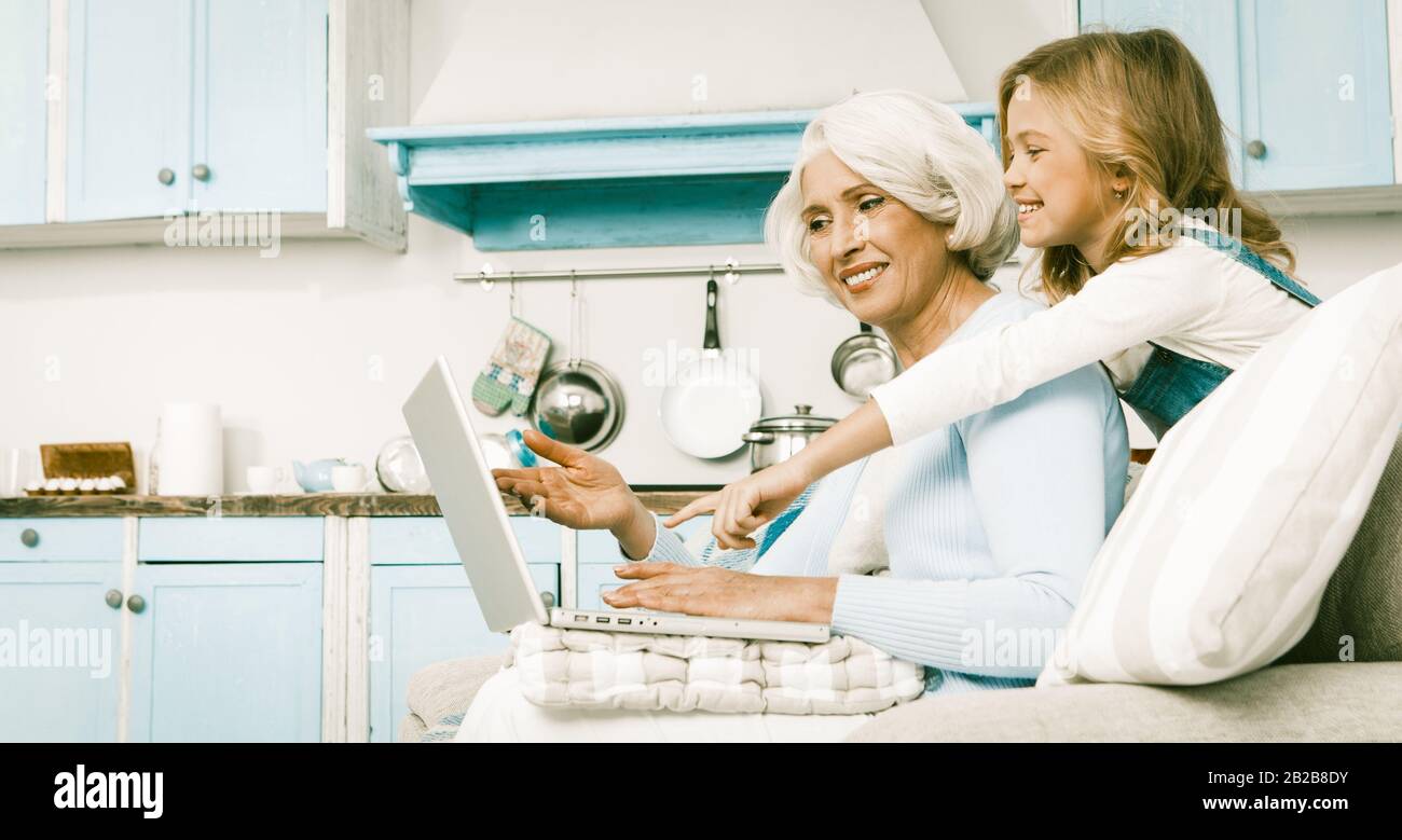 Friendly Family Granny And Little Girl Using Laptop Stock Photo